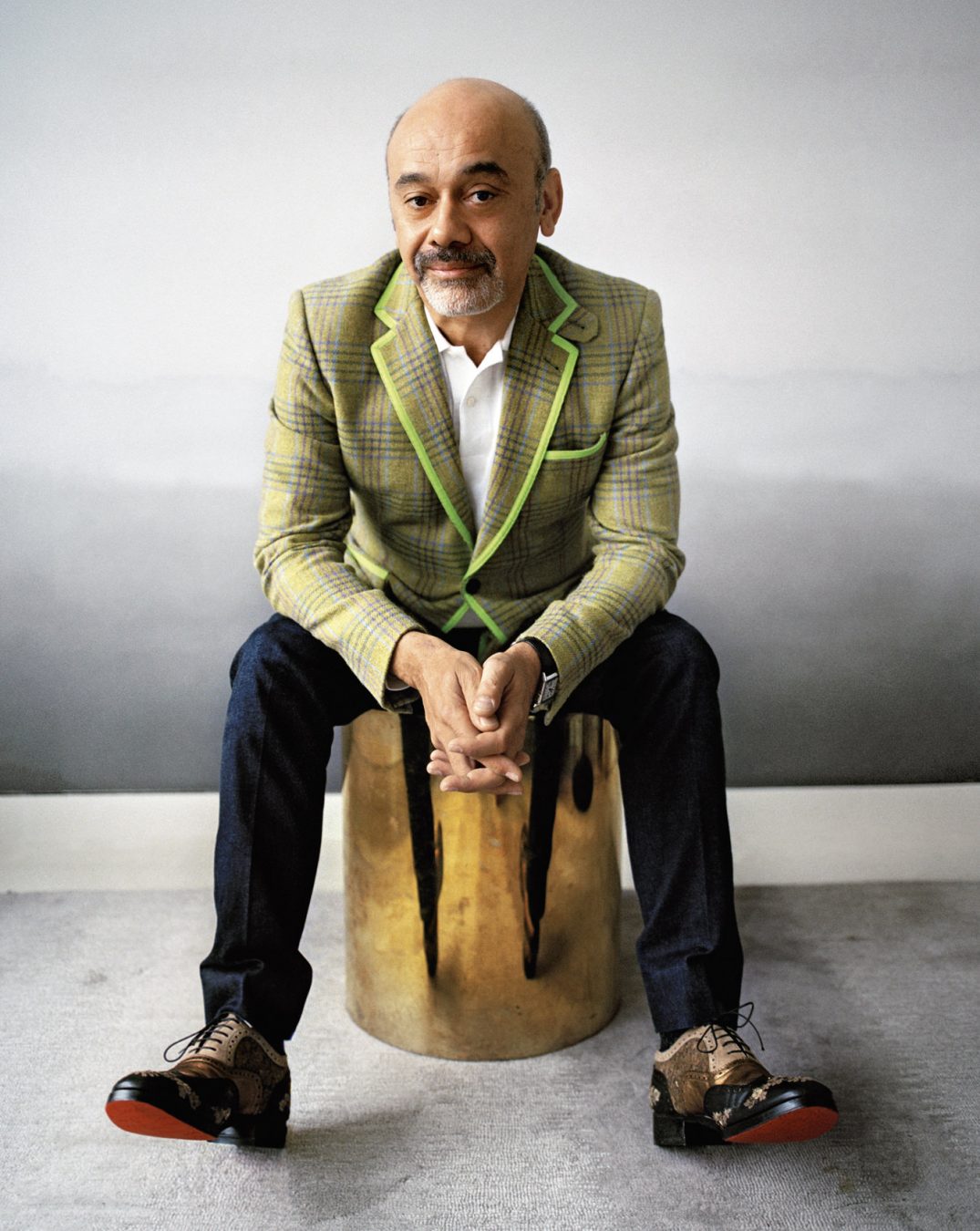 French shoe designer Christian Louboutin poses with his award at