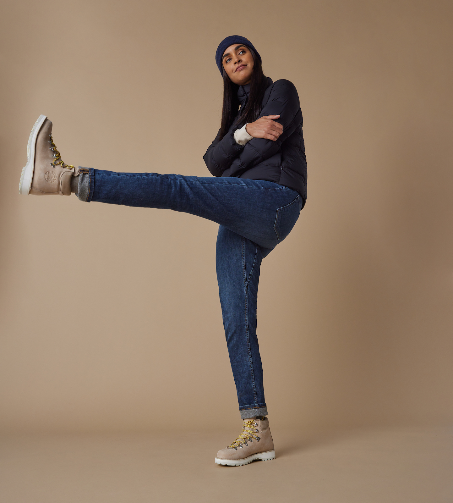 Woman wearing jeans and kicking up one leg