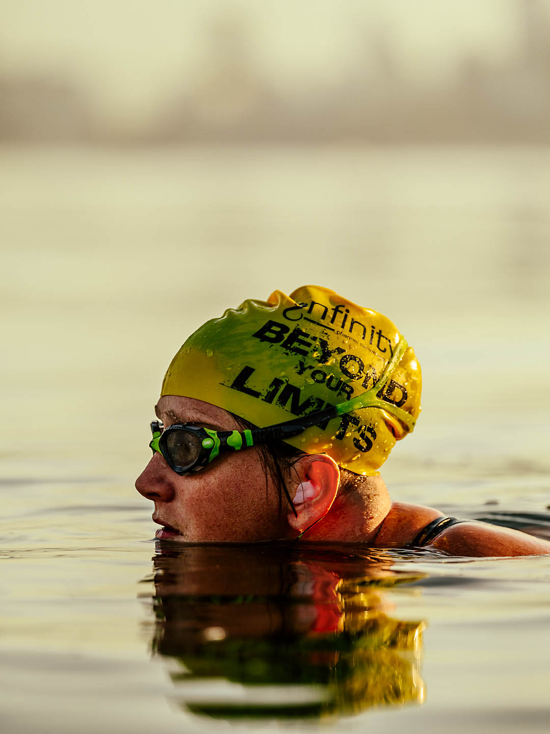 Close-up of Jessi Harewicz swimming while wearing goggles and a swim cap