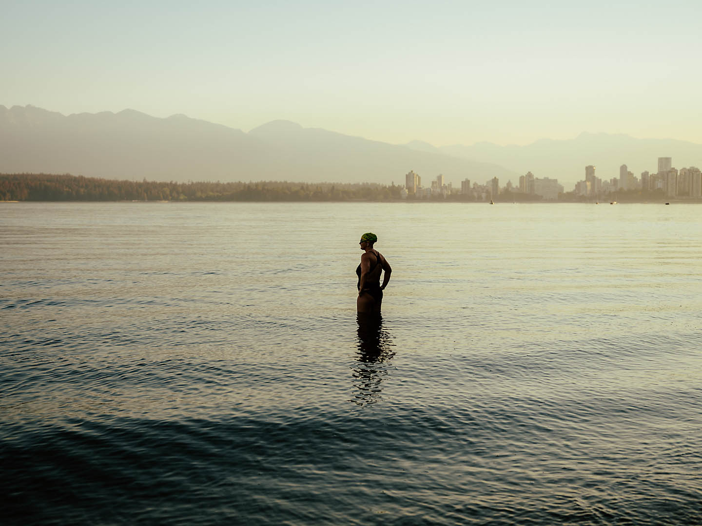 Jessi Harewicz standing in the ocean with the city in the background
