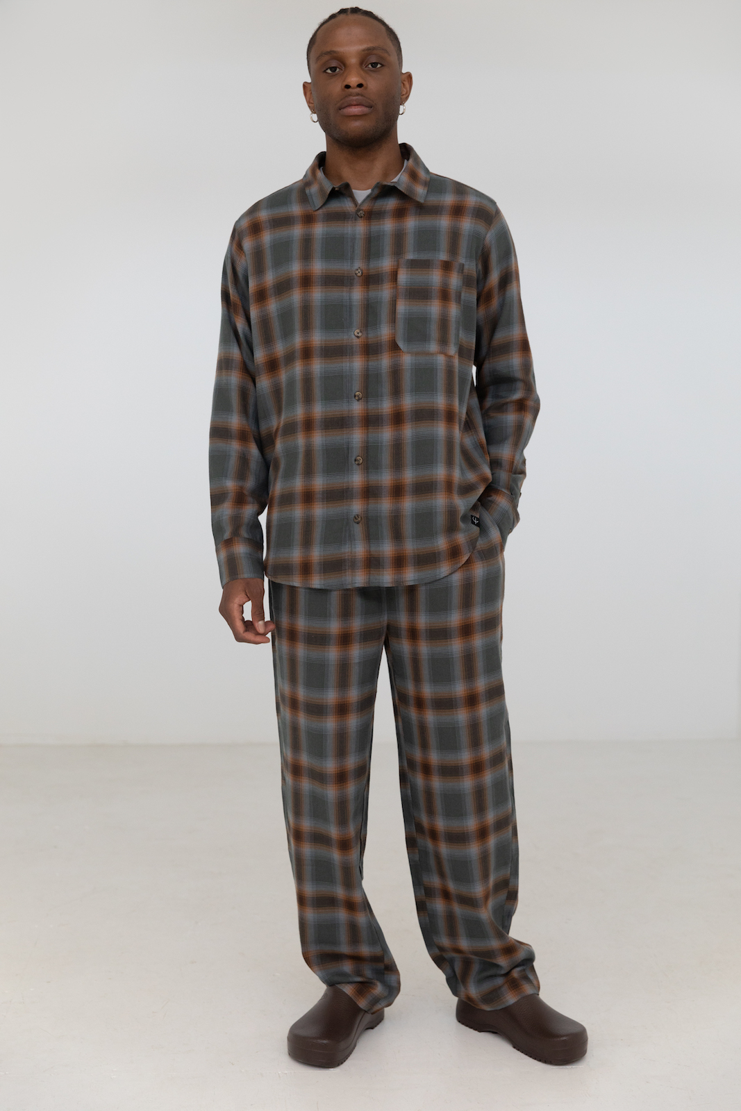 Man wearing matching plaid button-up shirt and pants