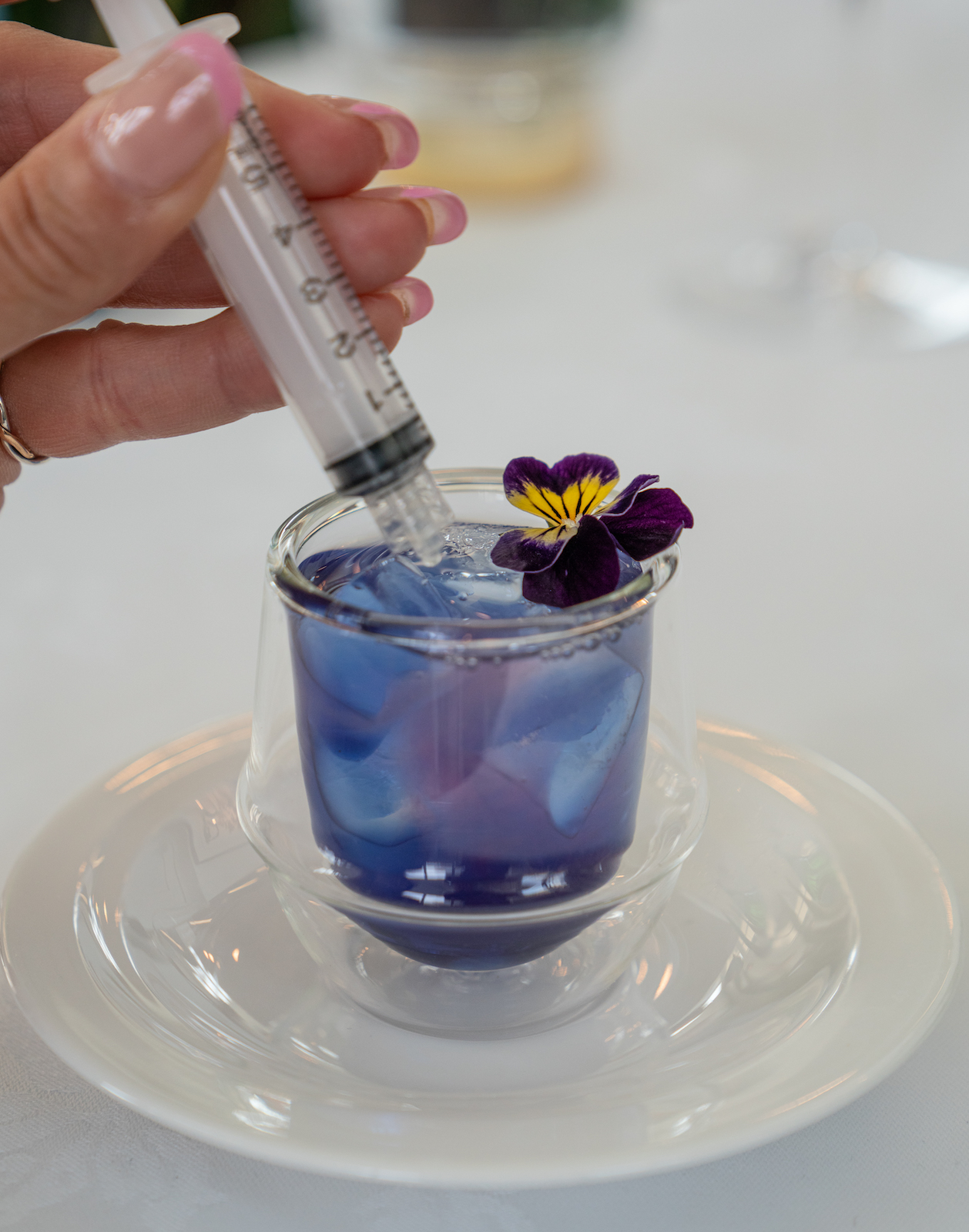 Syringe adding colour and flavour to a drink