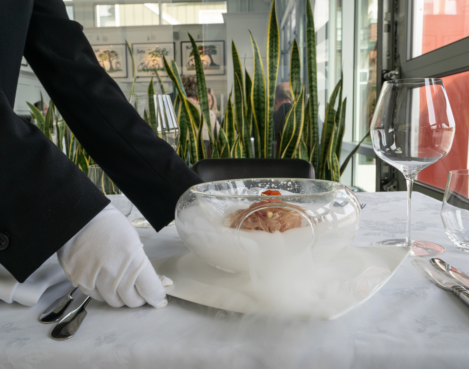 White-gloved server carrying pomelo salad