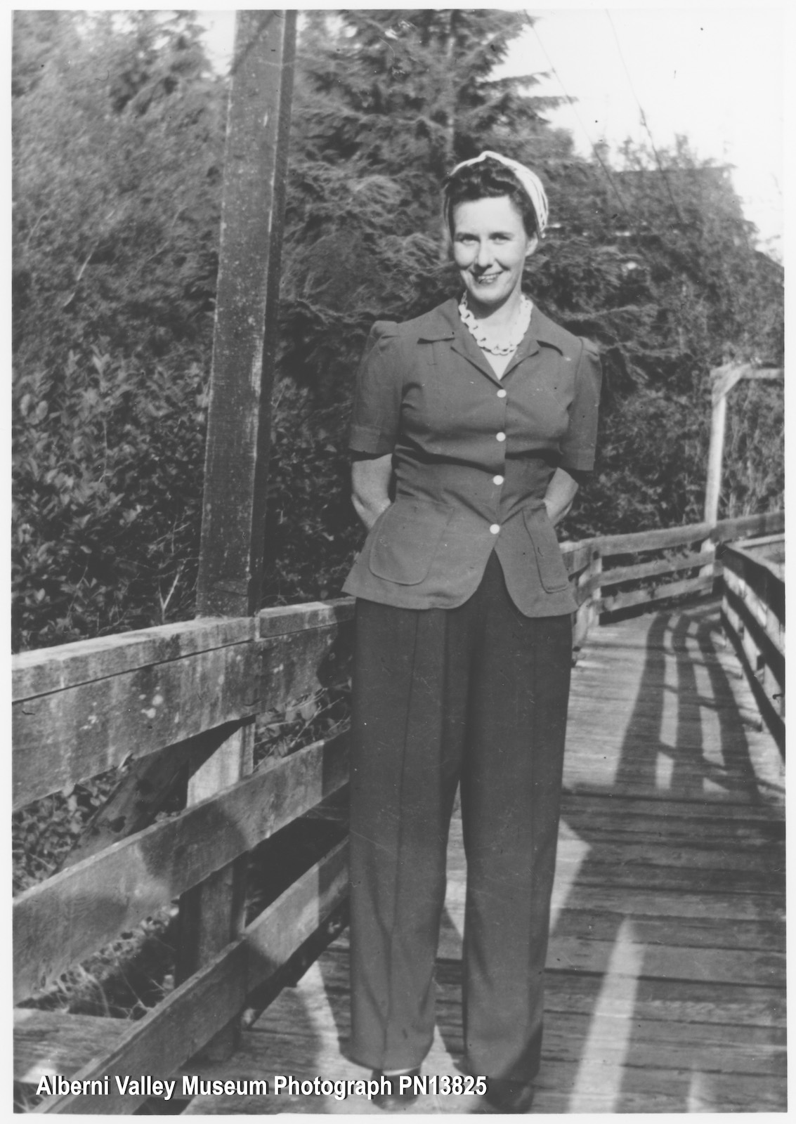 Black-and-white photo of Emmie May standing on a bridge