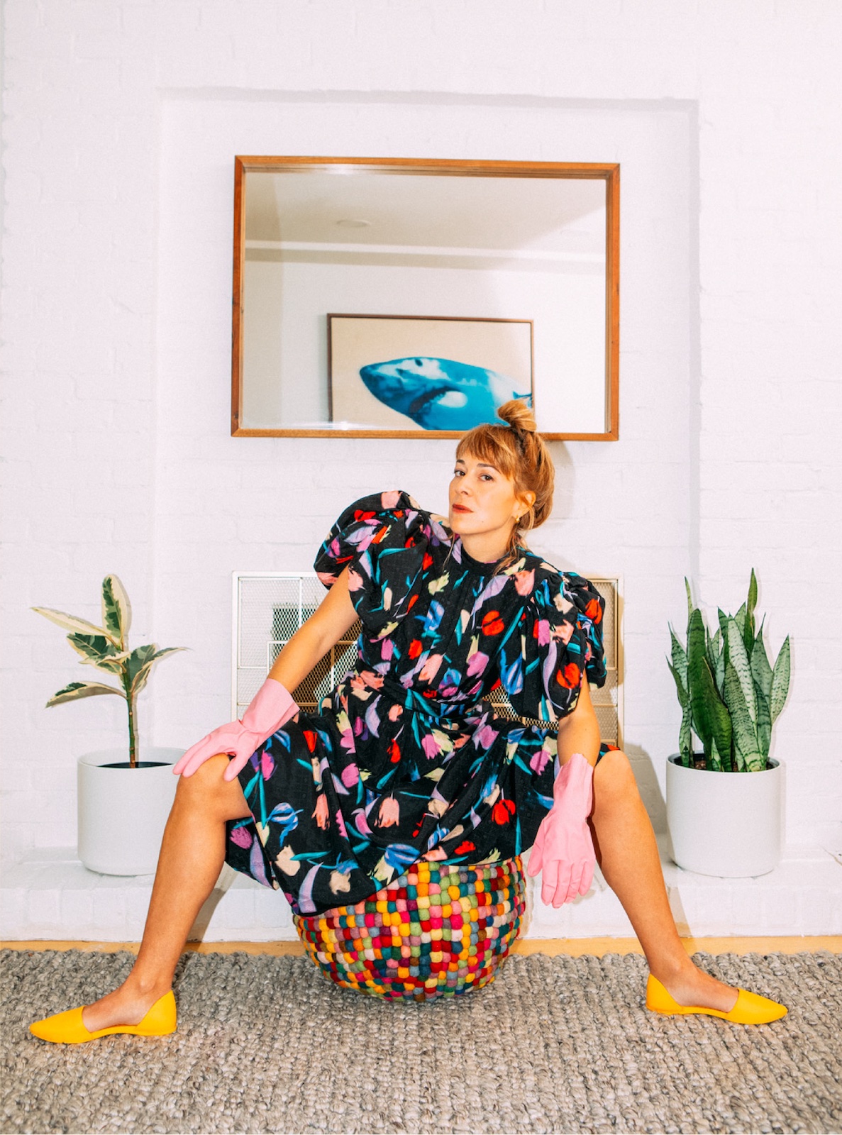 Jill Barber sitting while wearing a colourful dress and pink rubber gloves