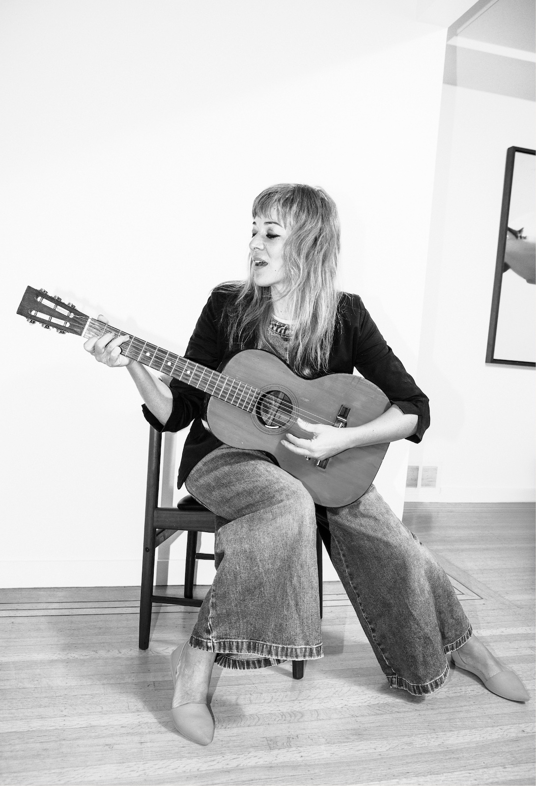 Black-and-white photo of Jill Barber playing a guitar 