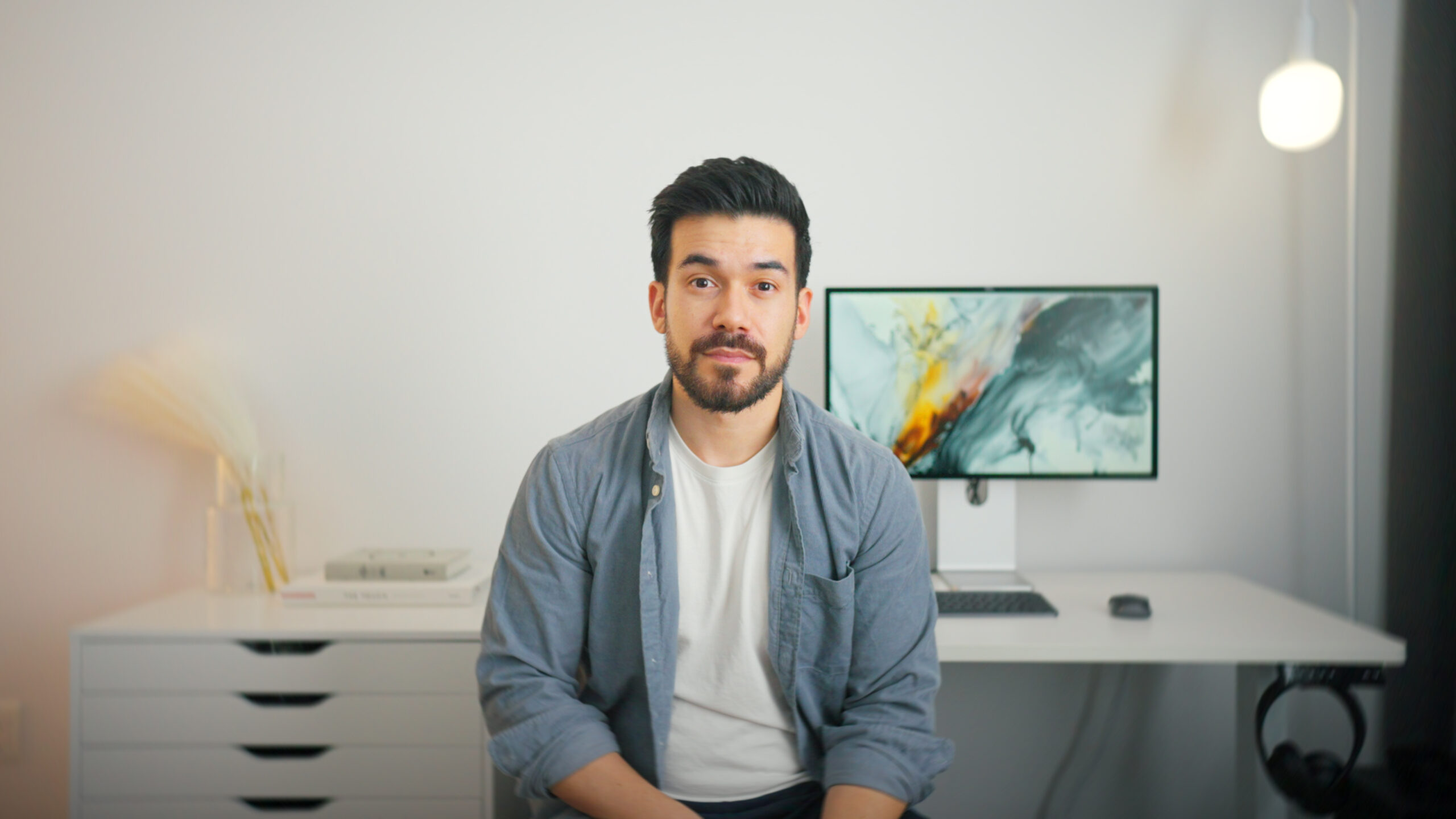 A man sits at a desk looking at the camera.