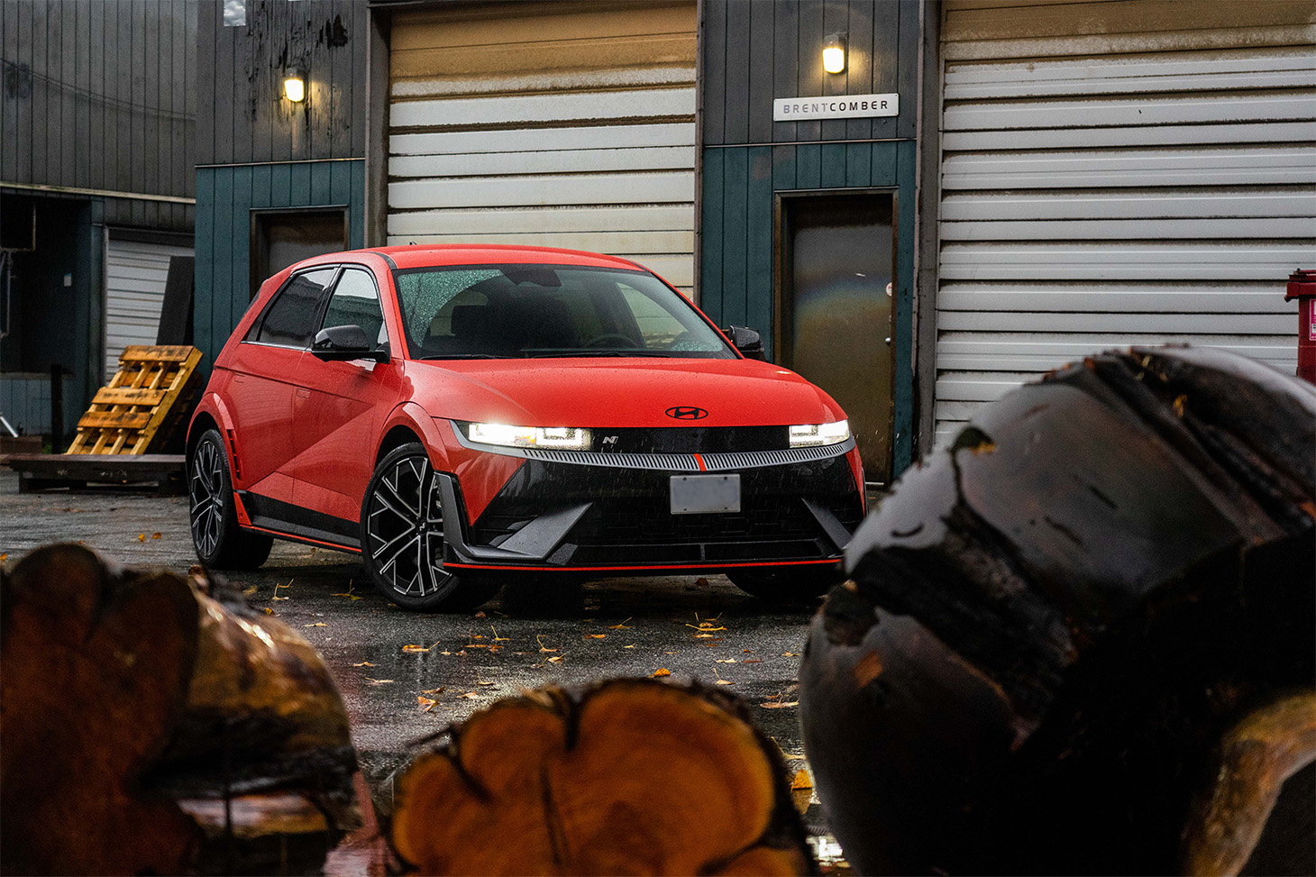 A red Hyundai Ionic 5 N parked in a lumber mill.