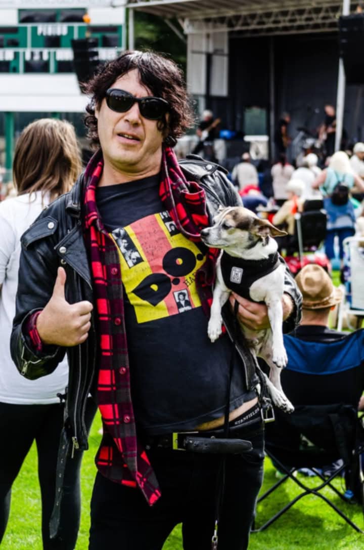 Billy Hopeless holding Bean the dog at a music festival