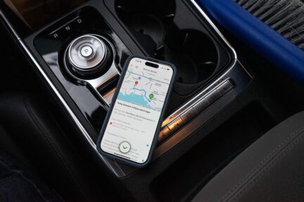 A cell phone on a car console, the screen displaying the Vancouver Food Runners app.