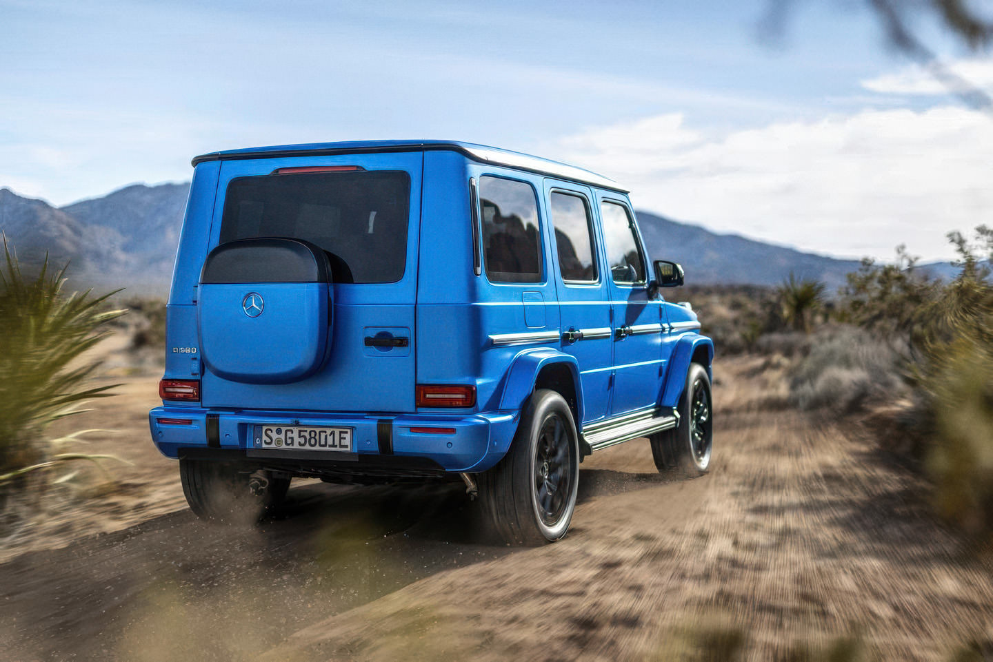 A blue Mercedes-Benz G-Class shot from behind.