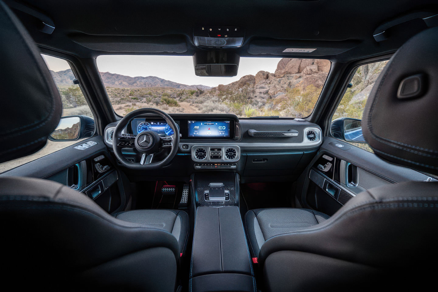 The interior of a Mercedes G-class, shot from the back seat.