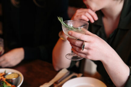 A woman holds a non-alcoholic cocktail in a martini glass