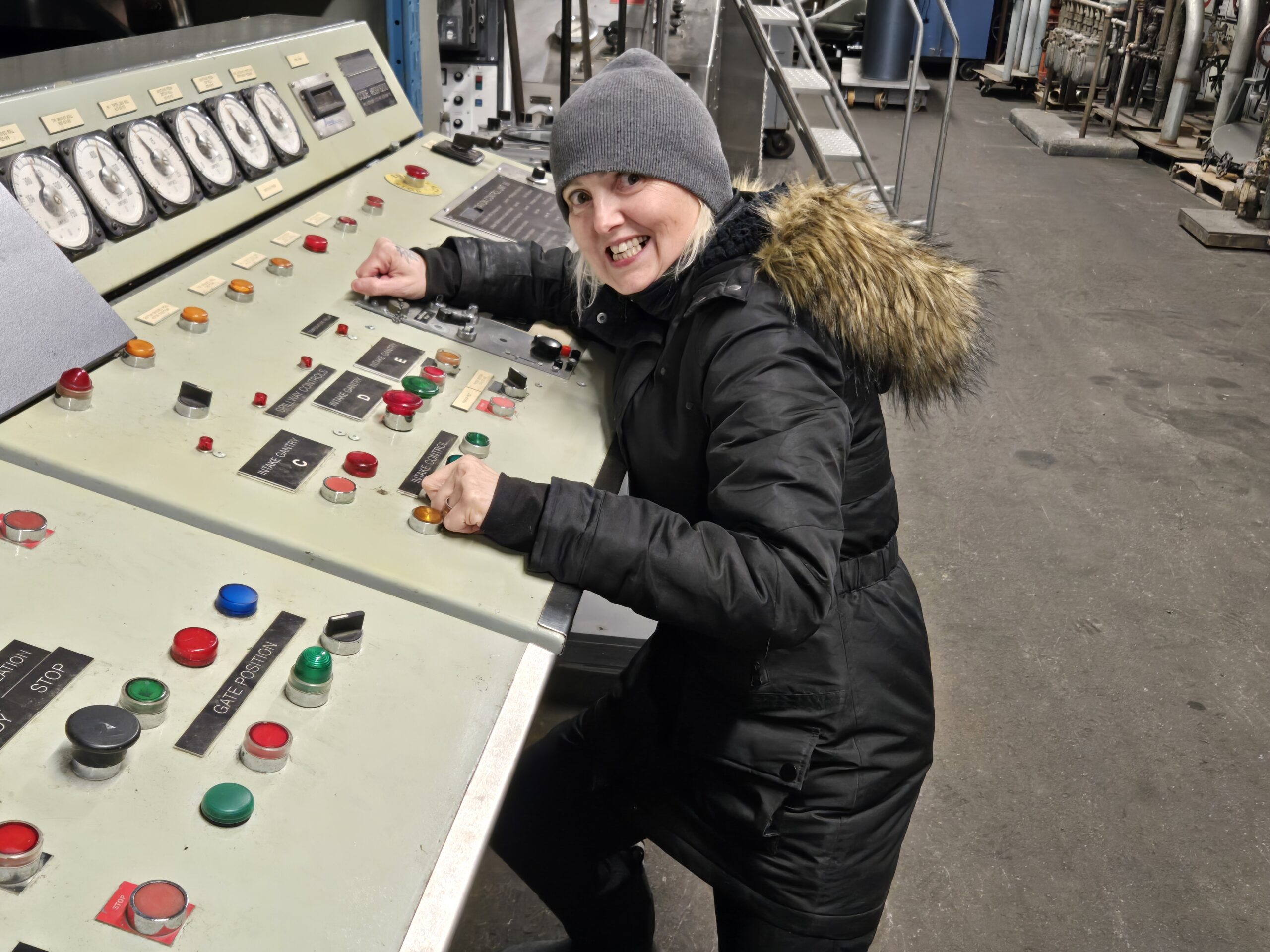 Ani Kyd Wolf at a control panel in a warehouse.