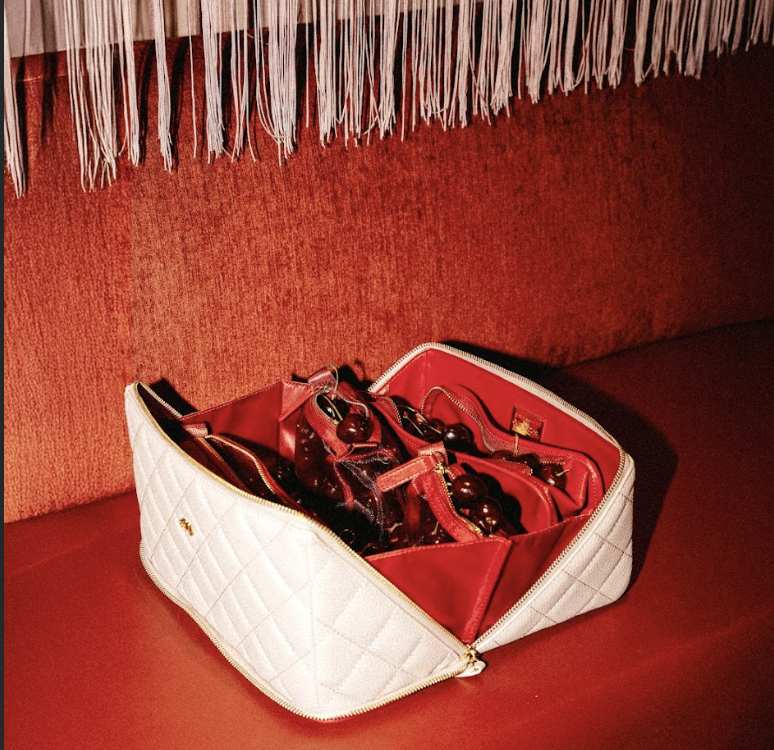 Fresh cherries inside a white leather purse.