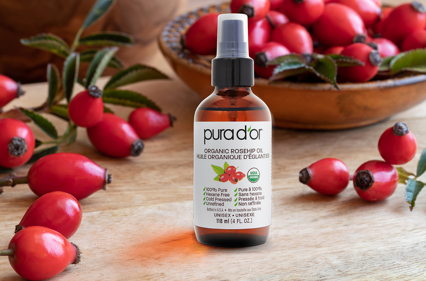 A bottle of rosehip oil surrounded by rosehips as part of the May wishlist.