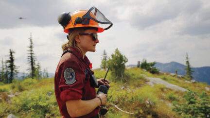 A firefighter surveys a landscape outdoors during B.C. wildfires.