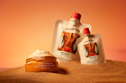 Containers of skin cream in the sand.