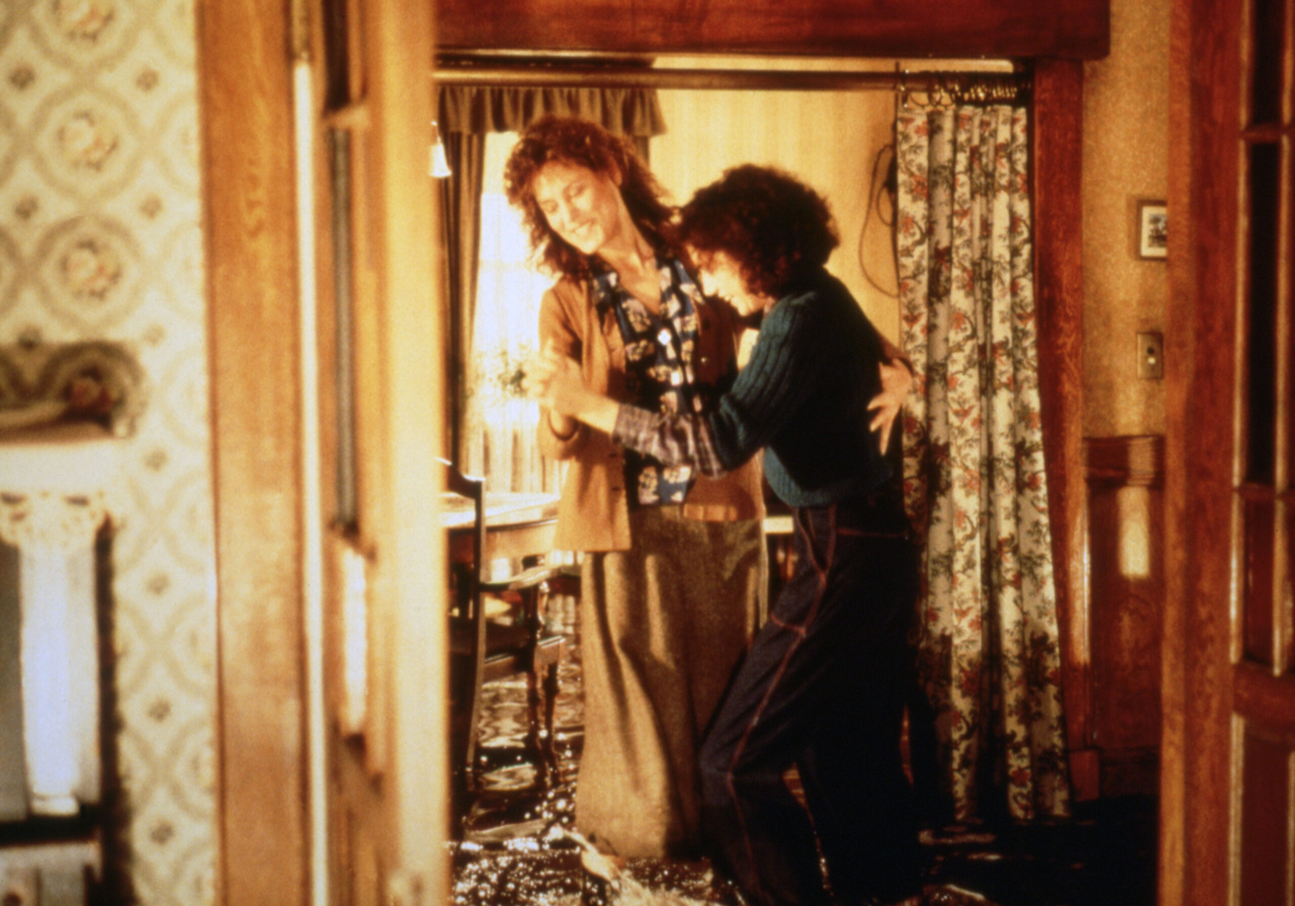 Two women dance, arm in arm, in a living room in Bill Forsyth's Housecleaning.