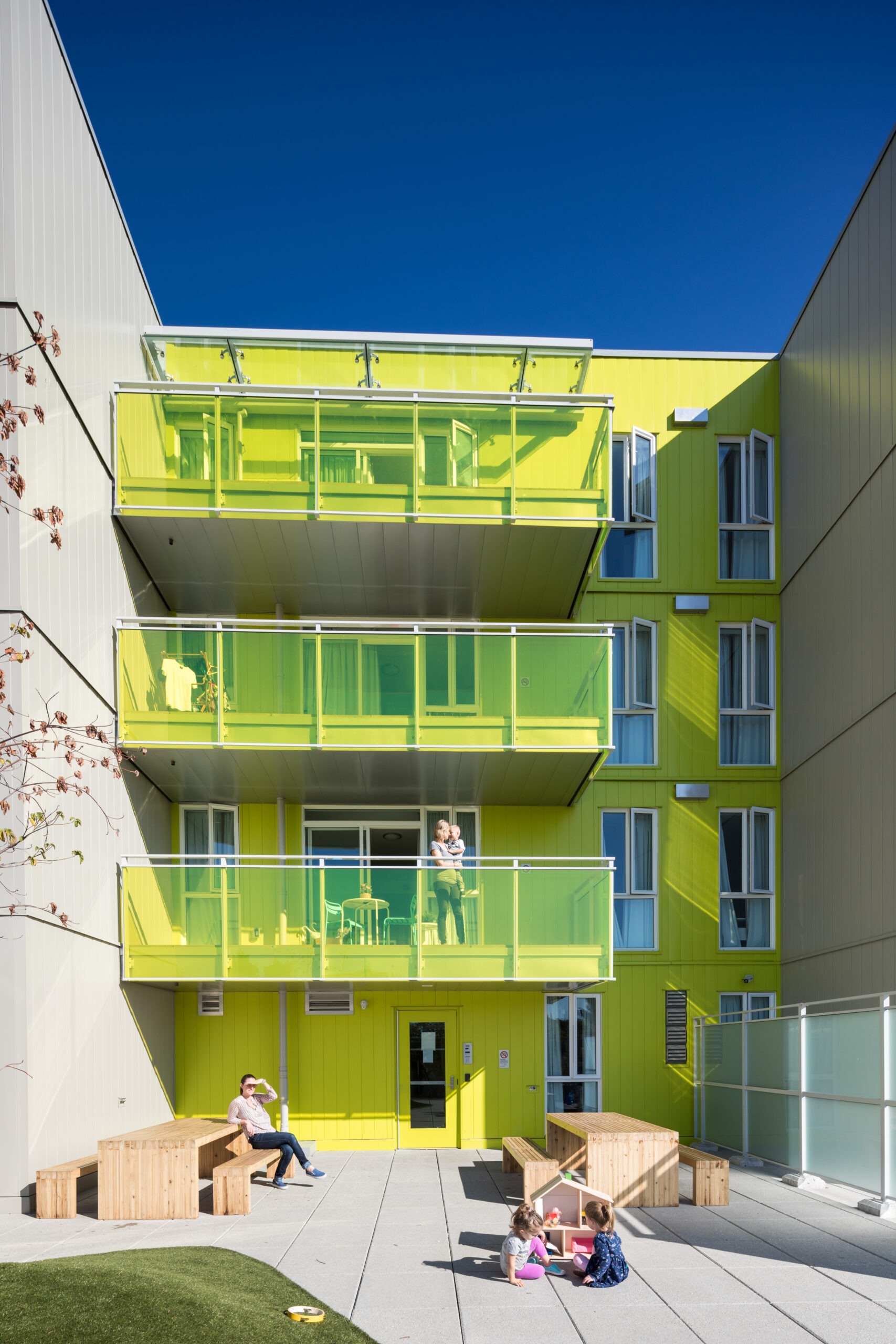 The exterior of a Cause We Care building, featuring green tinted balconies