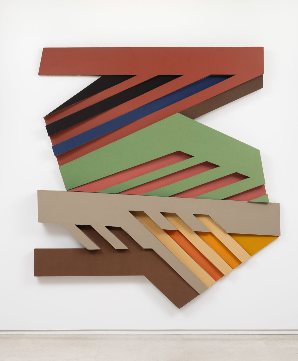 A multi-coloured sculpture hangs on a white wall in the Vancouver Art Gallery.
