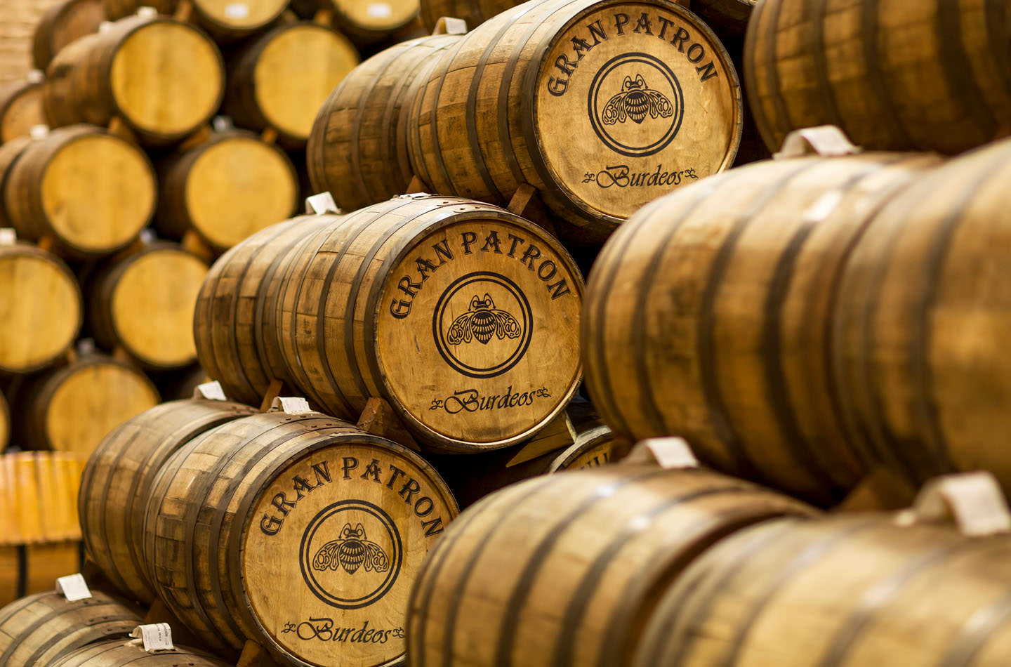A stack of wooden barrels labelled "Gran Patrón, Burdeos."