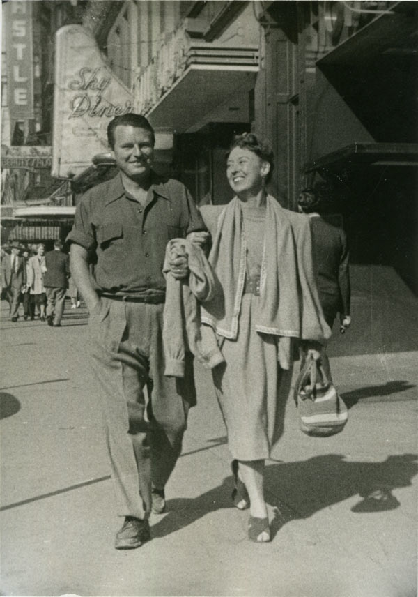 A black and white image of Malcolm Lowry and Margerie Lowry walking down a Vancouver street.