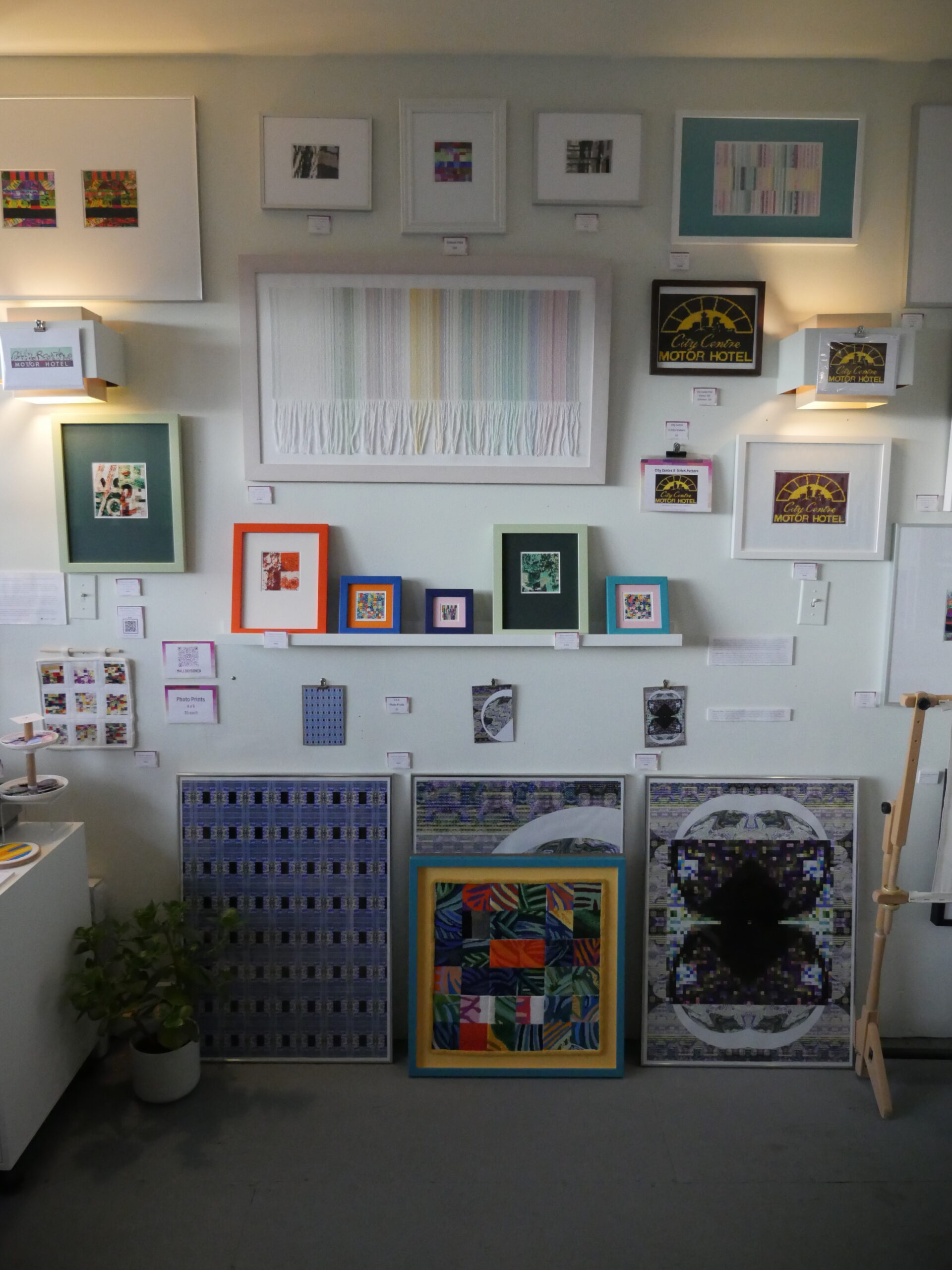 An assortment of artworks hanging on a wall in Mallory Donen's studio.