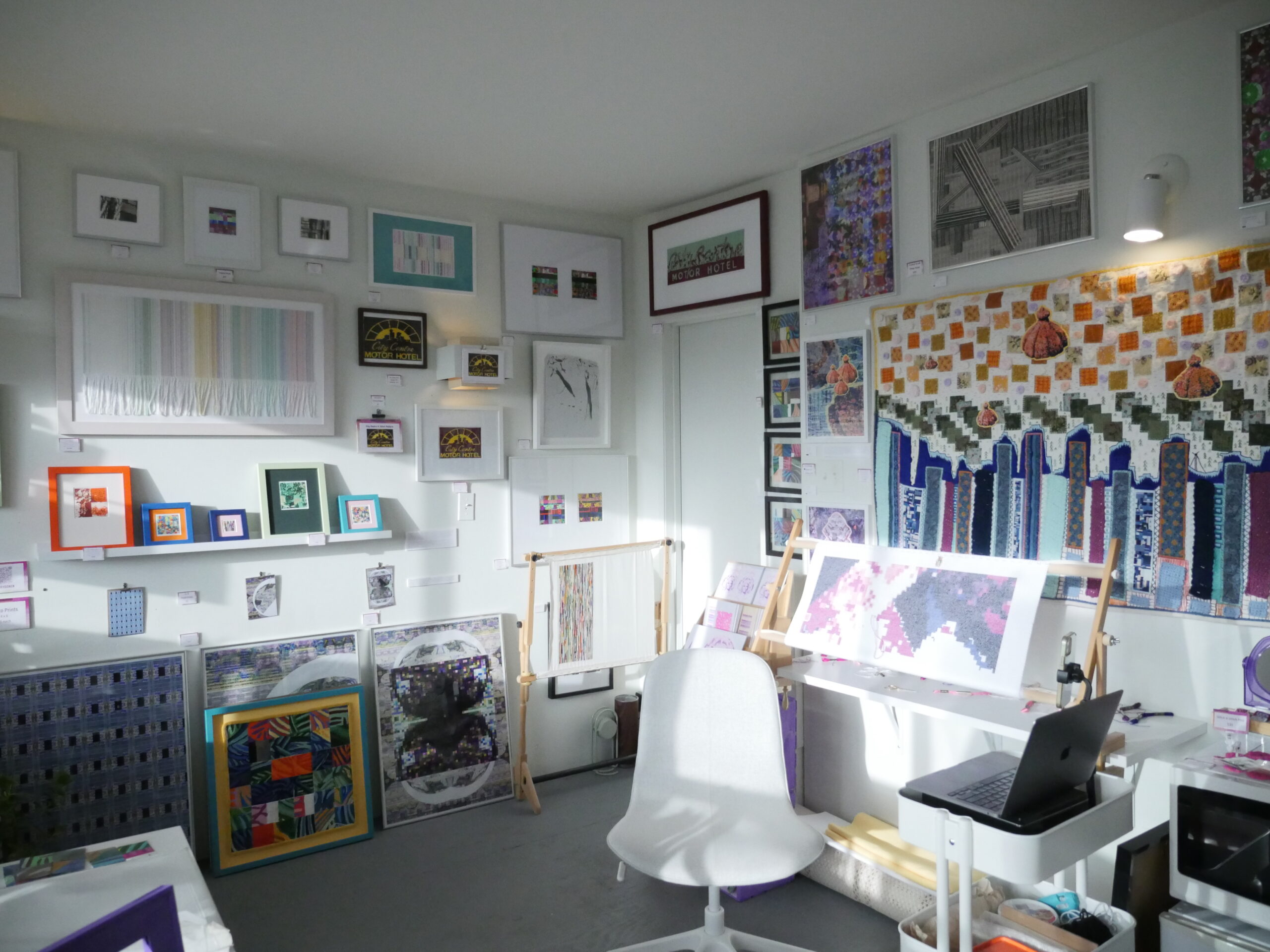 The interior of Mallory Donen's studio, full of her art projects (canvases, prints, framed paintings, and textiles).