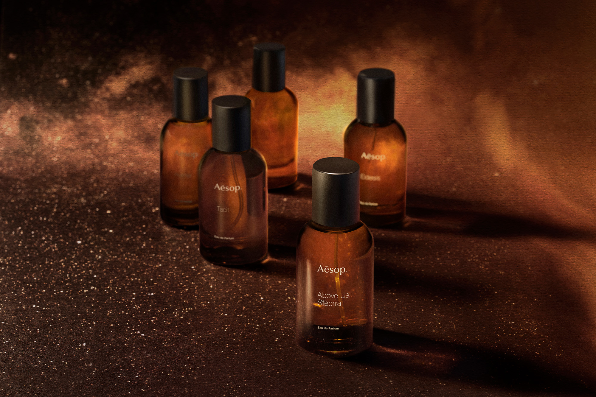 Bottles of Aesop fragrances set amid the night sky and cosmos.