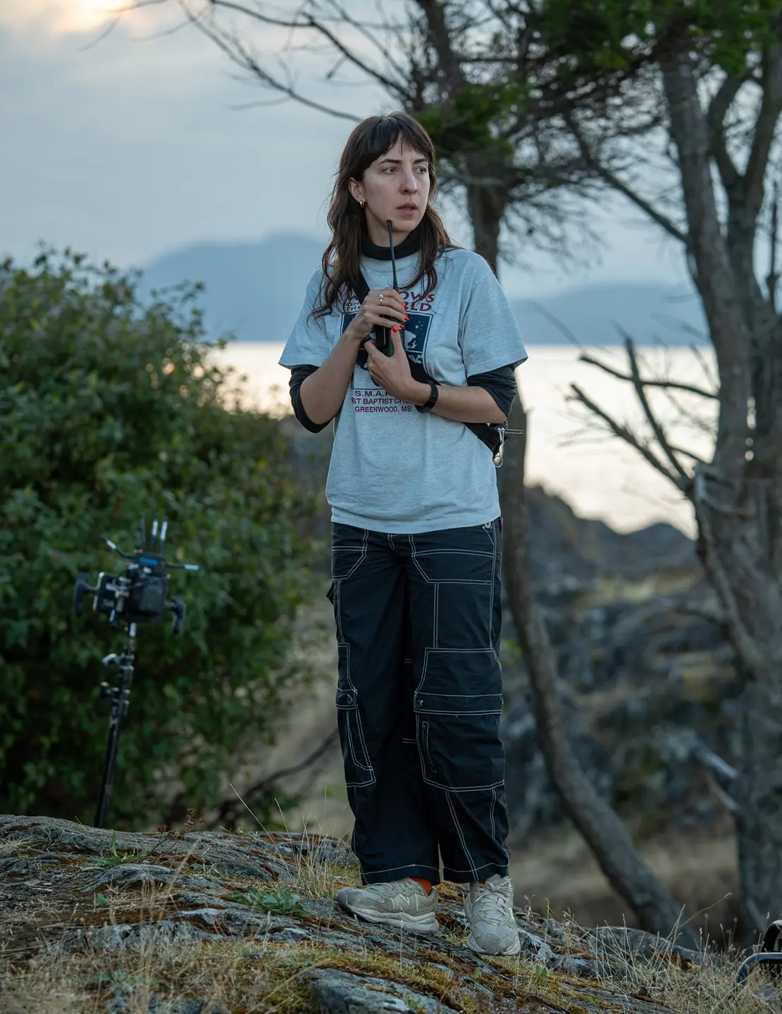 A woman, Sophy Romvari, clutches a walkie talkie in her hands.