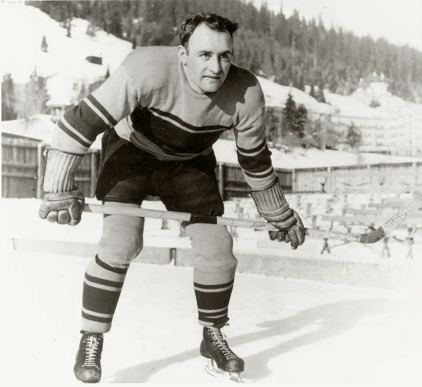 A black and white photo of Mike Buckna in hockey gear on an outdoor rink.
