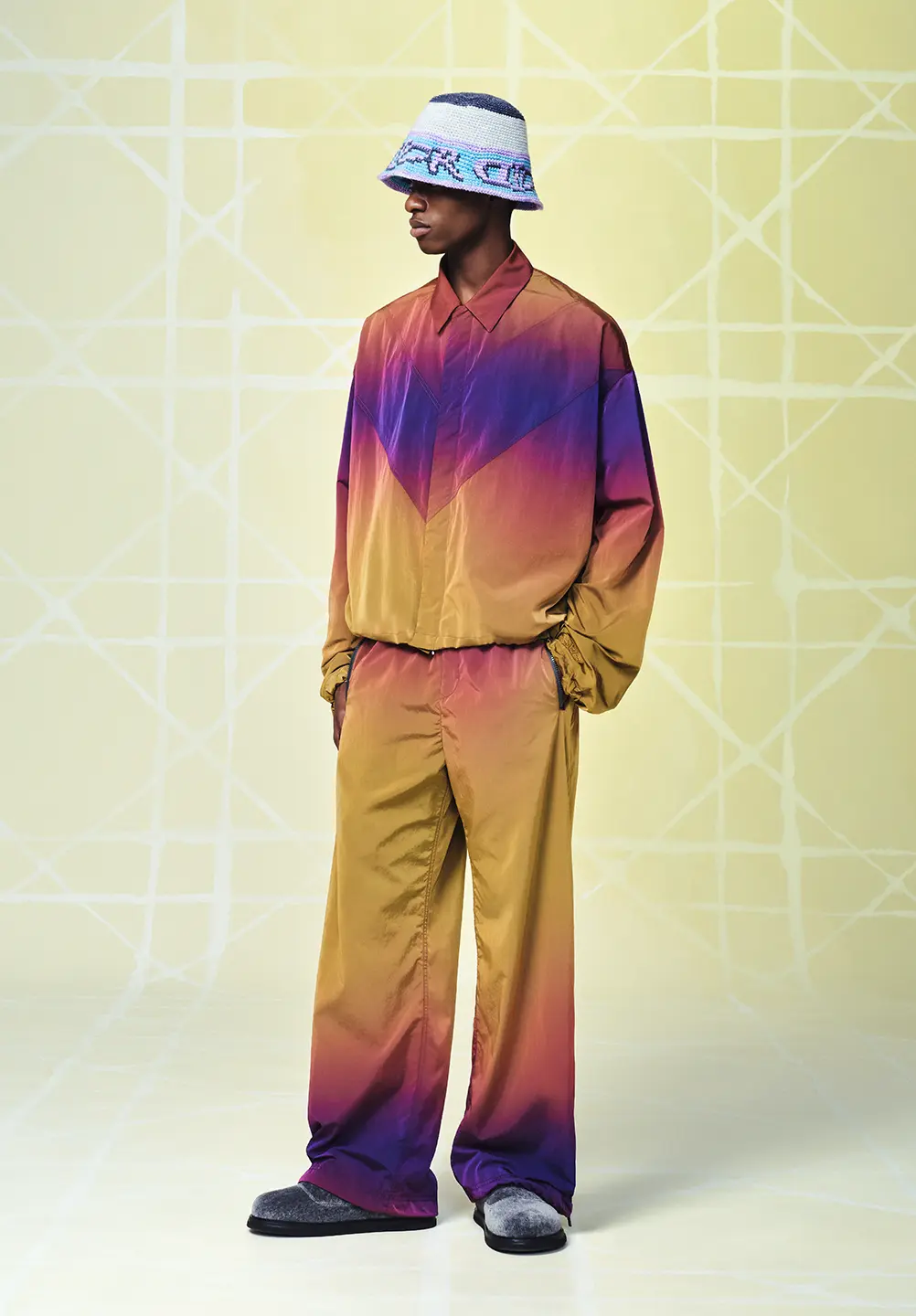 A man stands in a colourful tracksuit.