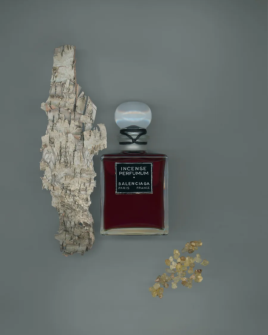 A bottle of balenciaga fall fragrance surrounded by tree bark.