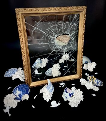 A work of art: a broken window surrounded by shattered and restored pottery.