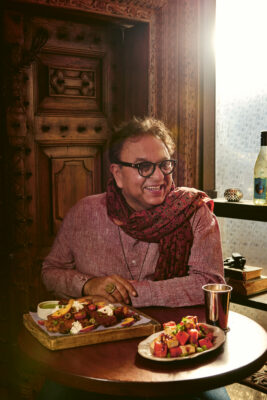 A man sits at a dining table in front of food.