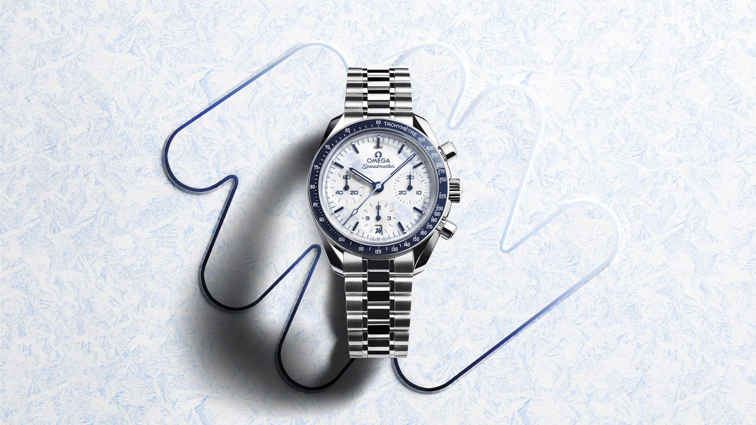 A silver watch over a textured white background - luxury holiday gift guide