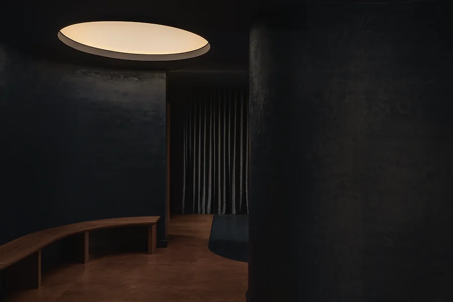 An interor shot of Jaybird. A rounded bench sits below a large, diffused light source.