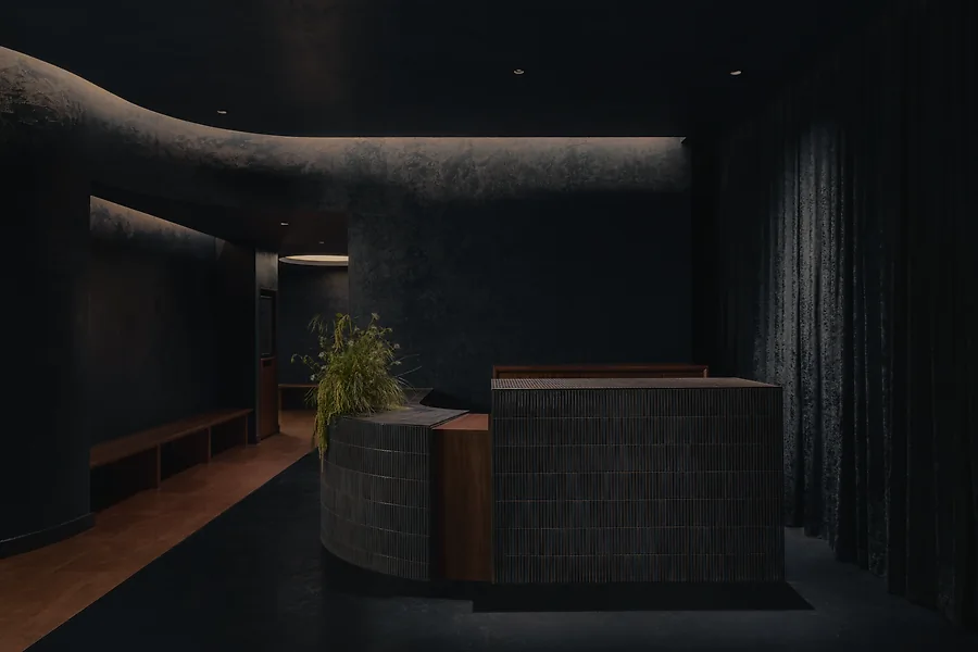 The lobby of Jaybird on Kingsway. A dark room with rounded edges and a reception desk.