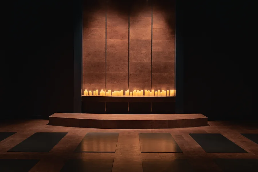 Yoga mats in front of an altar of candles.