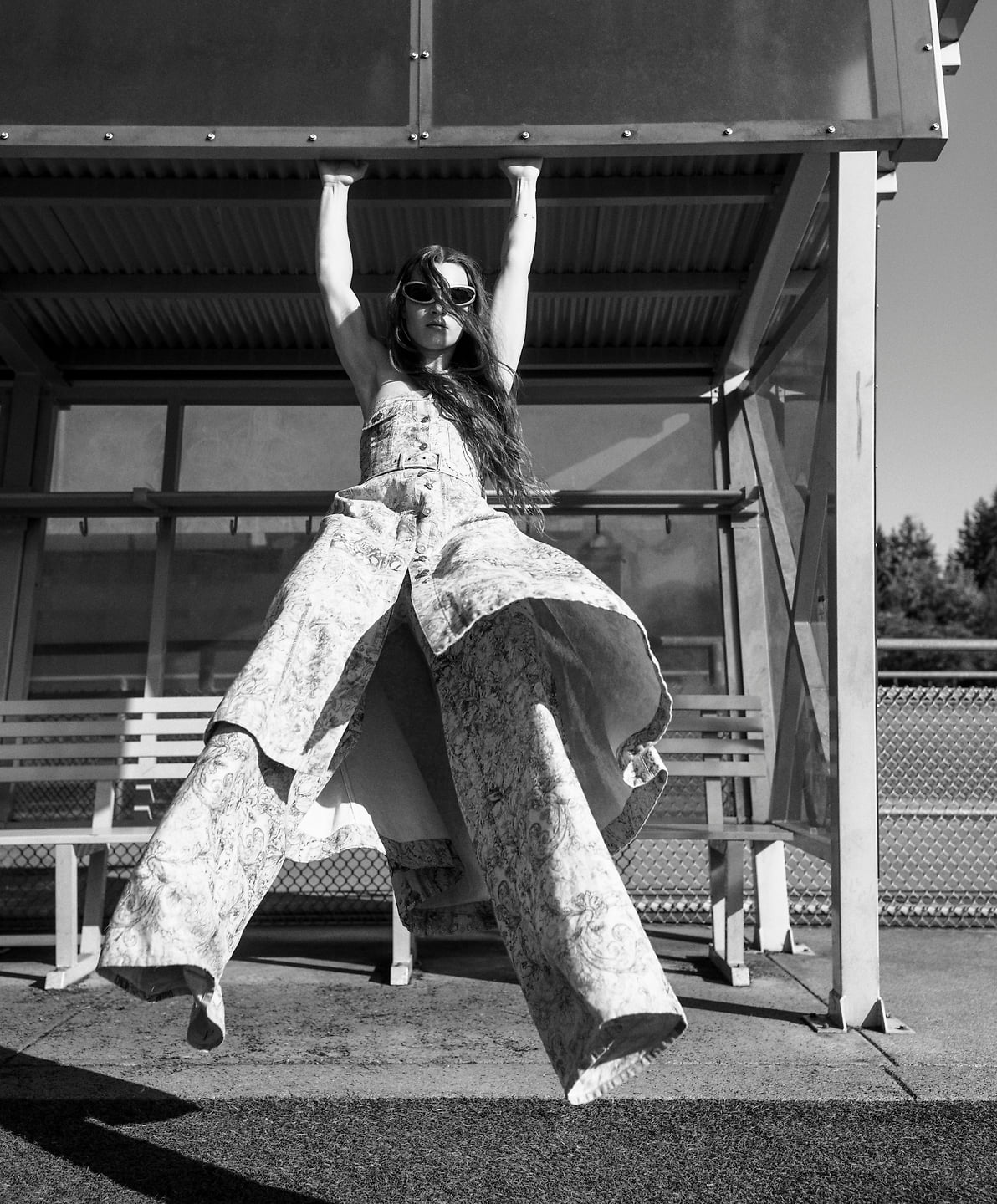 A black and white photo of Sophia Stel swinging from a beam.