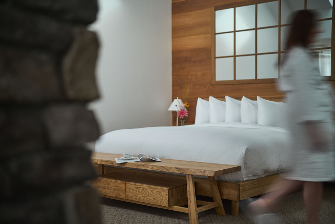 A woman in a bathrobe in a hotel room.