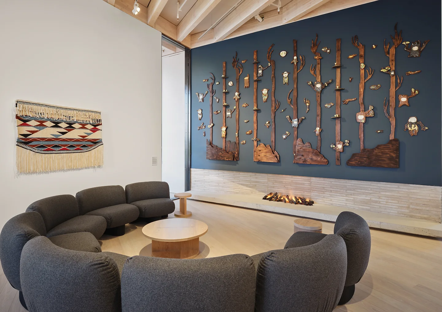 A seating area in the Marianne and Edward Gibson Art Museum surrounded by art on the walls.