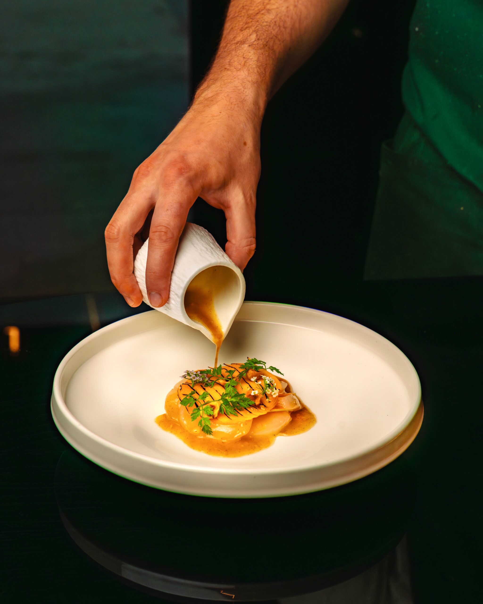 Sauce is poured onto a plate of food.