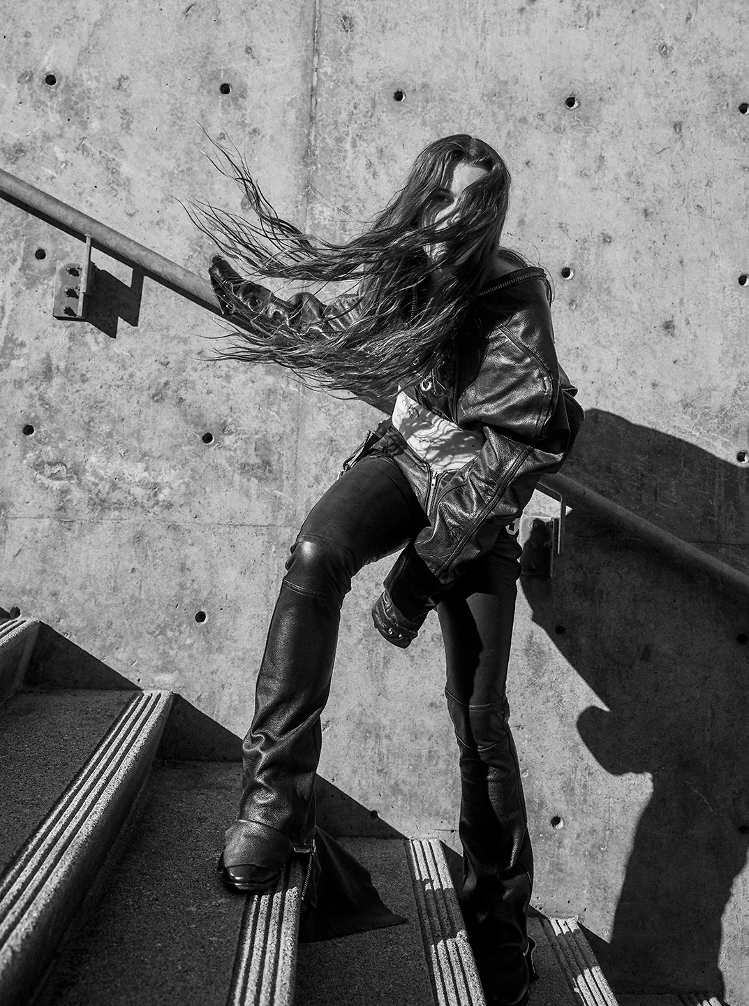 A black and white photo of a woman on a stairway.