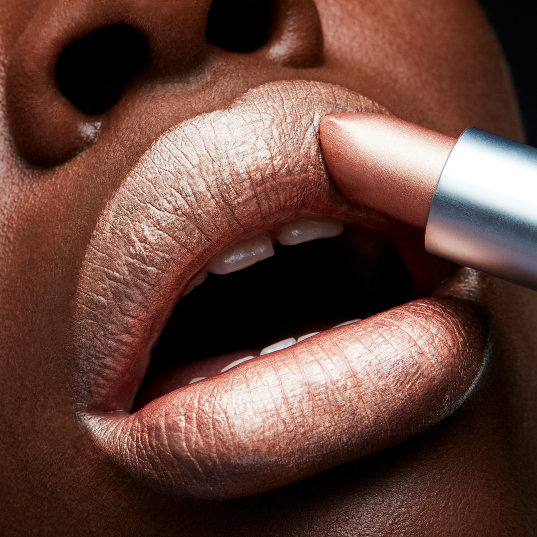A woman applies lipstick.