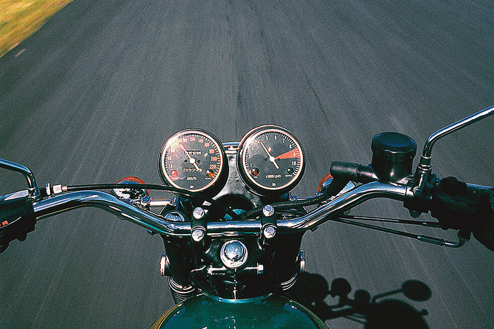 a POV shot of motorcycle handlebars.