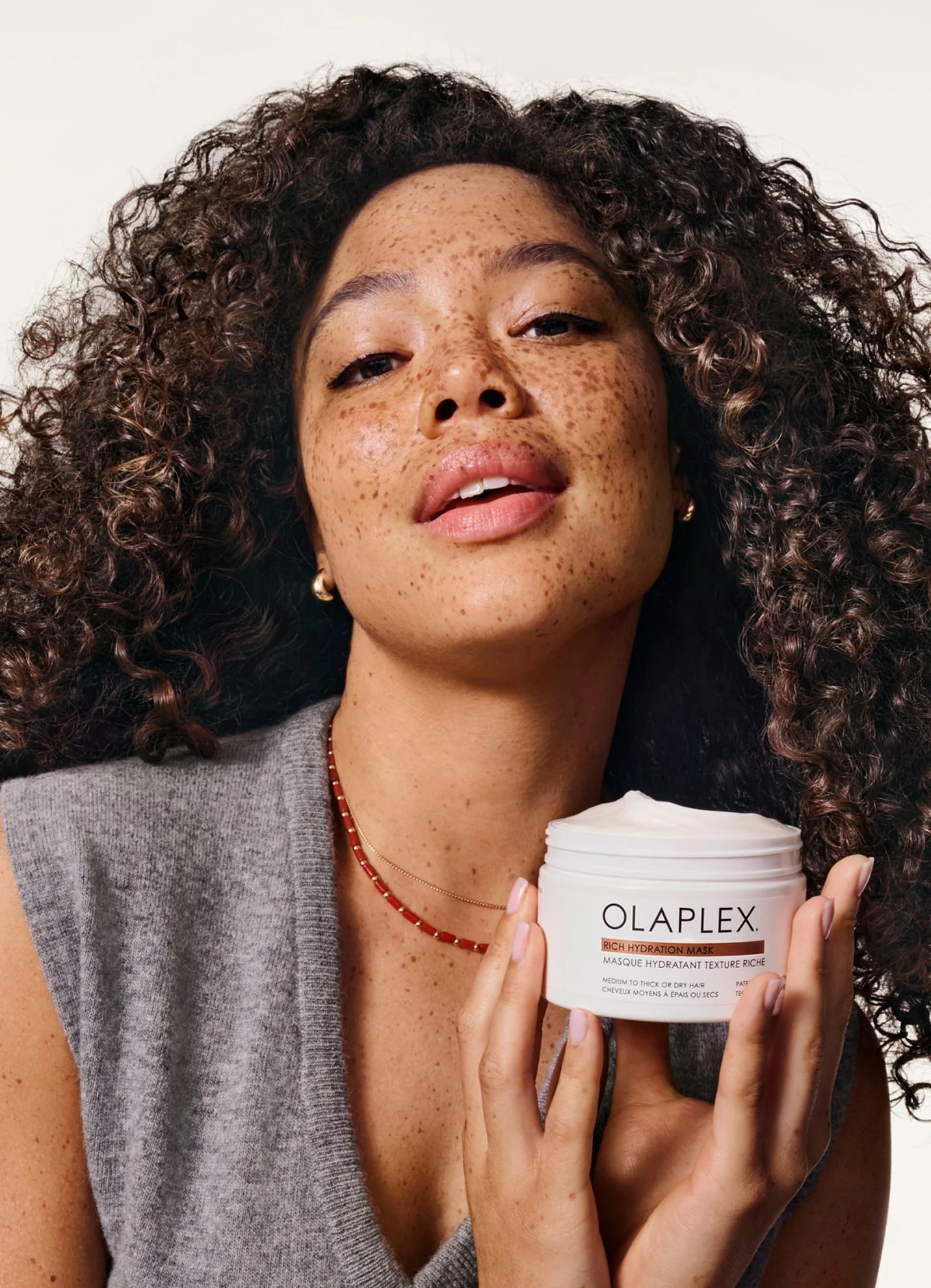 A woman holds up an Olaplex product - wishlist