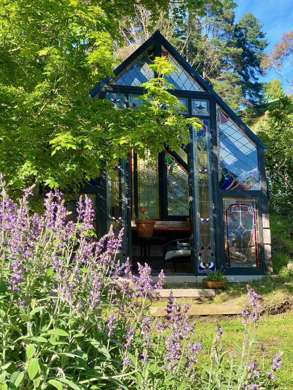 A glass greenhouse in a garden.