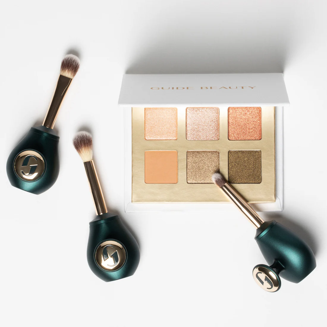 An eyeshadow palette with three brishes.